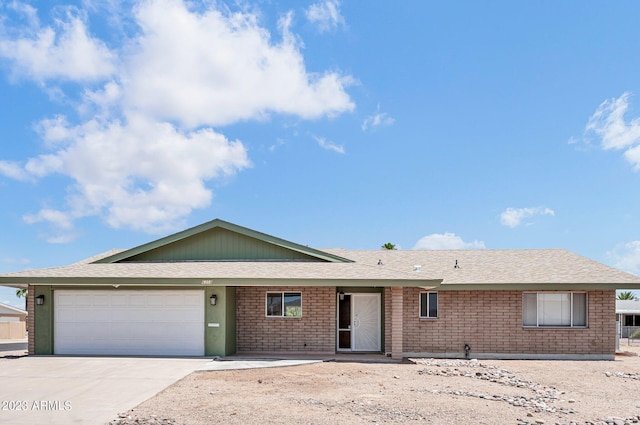 ranch-style house with a garage, brick siding, driveway, and a shingled roof