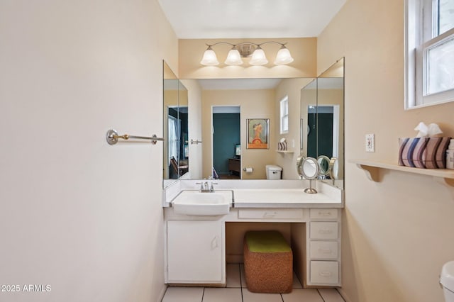 ensuite bathroom with tile patterned floors, baseboards, vanity, toilet, and ensuite bathroom