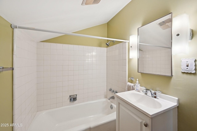bathroom featuring vaulted ceiling, bathing tub / shower combination, visible vents, and vanity