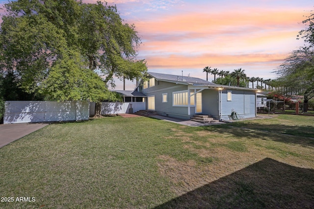 back of house with fence and a yard