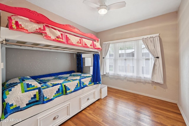 bedroom with a ceiling fan, baseboards, and wood finished floors