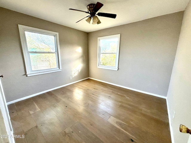 spare room featuring hardwood / wood-style flooring, ceiling fan, and a wealth of natural light