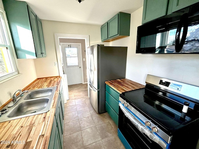 kitchen with sink, butcher block counters, stainless steel appliances, and green cabinetry