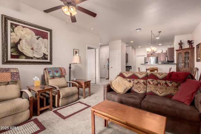 living room with ceiling fan with notable chandelier and light carpet