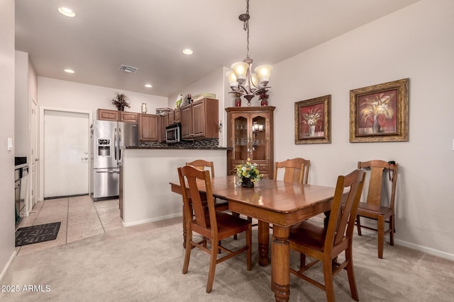 carpeted dining area featuring a chandelier