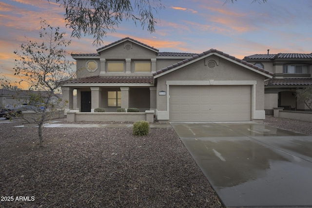 view of front of home with stucco siding, a garage, driveway, and a tiled roof