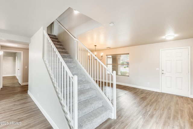 staircase with wood finished floors and baseboards