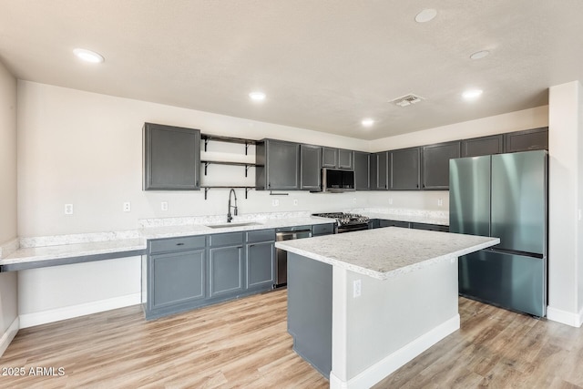 kitchen with visible vents, open shelves, light wood-style flooring, a sink, and appliances with stainless steel finishes