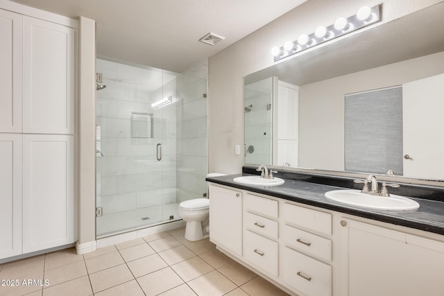 full bath featuring tile patterned flooring, a stall shower, and a sink