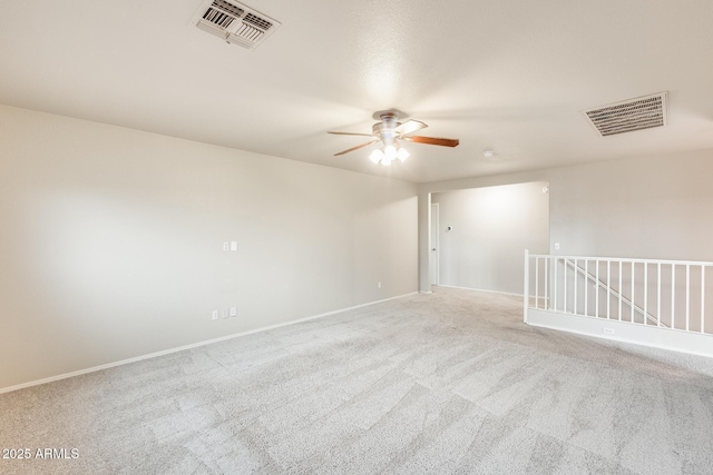 empty room featuring baseboards, visible vents, a ceiling fan, and carpet