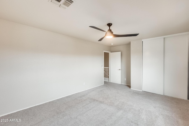 unfurnished bedroom with visible vents, baseboards, carpet, a closet, and a ceiling fan