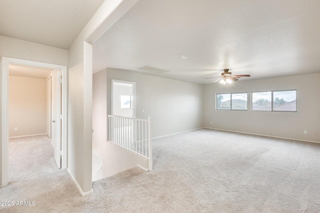 spare room with baseboards, visible vents, and carpet floors