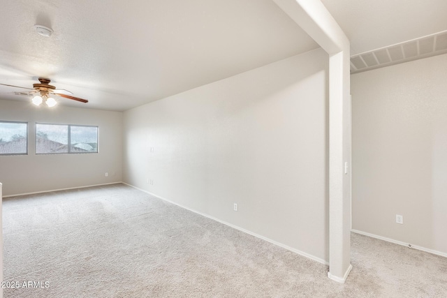 carpeted spare room with a textured ceiling, a ceiling fan, visible vents, and baseboards