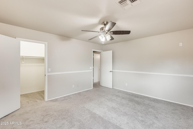 unfurnished bedroom with visible vents, carpet floors, baseboards, ceiling fan, and a spacious closet