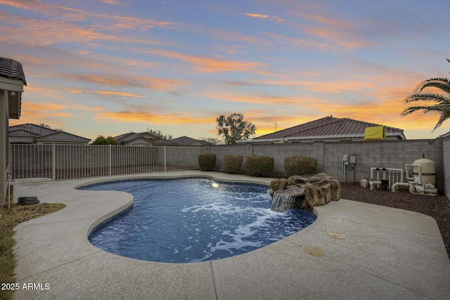 pool at dusk with a fenced in pool and a fenced backyard