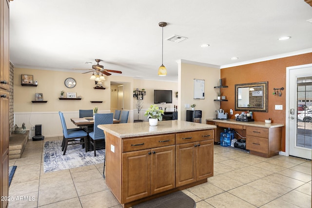 kitchen with visible vents, light countertops, ornamental molding, light tile patterned floors, and brown cabinetry