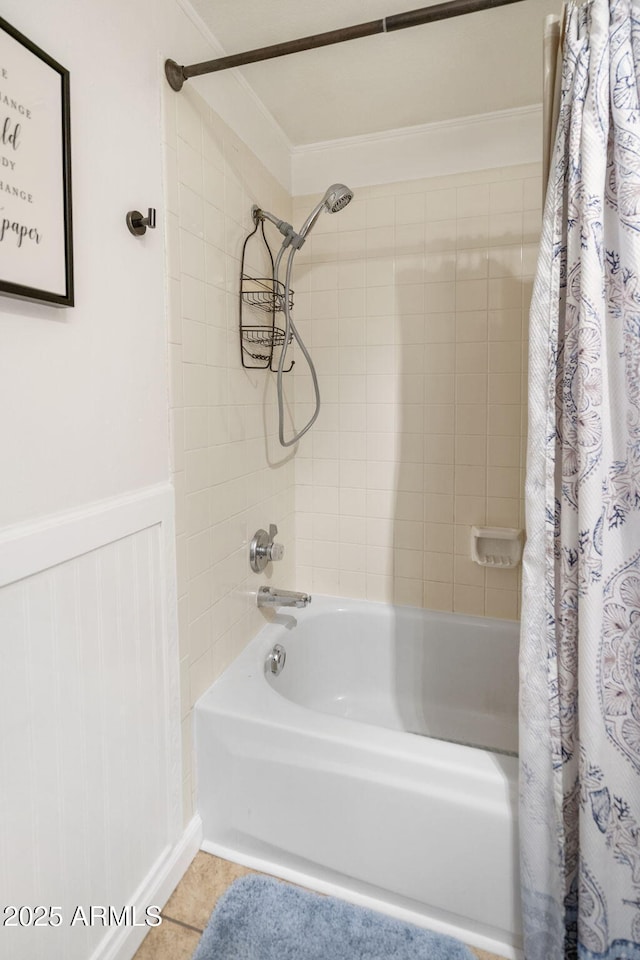 full bath with tile patterned floors, shower / bathtub combination with curtain, and wainscoting