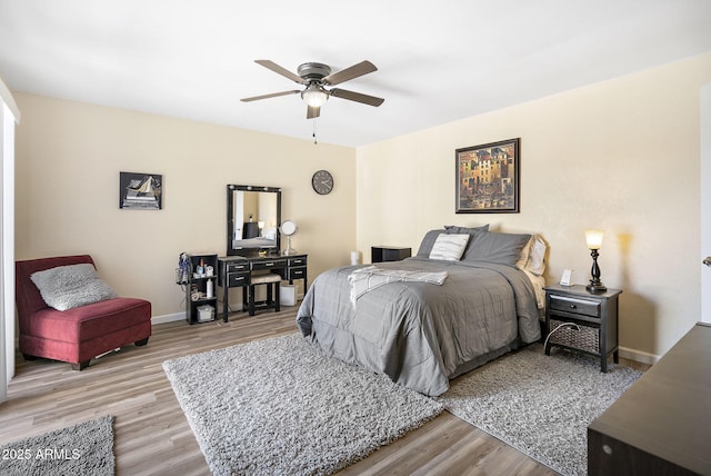 bedroom with light wood-type flooring, baseboards, and a ceiling fan