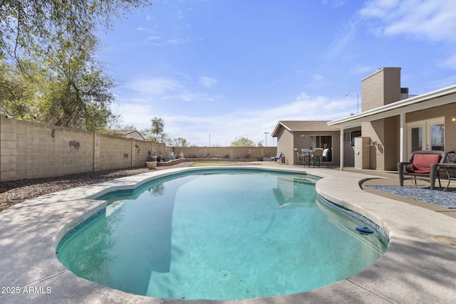 view of pool with french doors, a patio area, a fenced in pool, and a fenced backyard