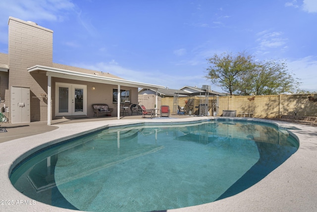 view of pool featuring a fenced in pool, french doors, a fenced backyard, and a patio