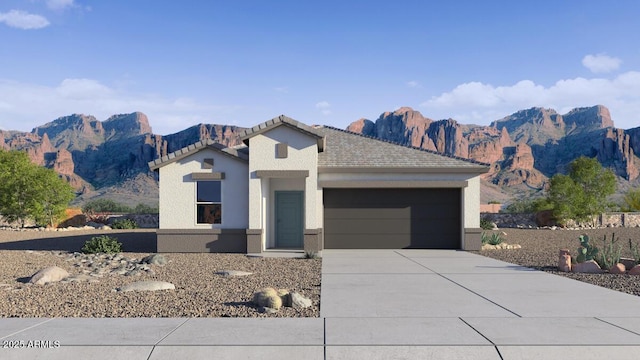 view of front facade featuring driveway, an attached garage, a mountain view, and stucco siding