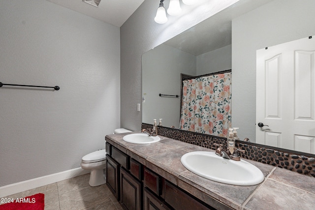 bathroom with tile patterned floors, vanity, walk in shower, and toilet