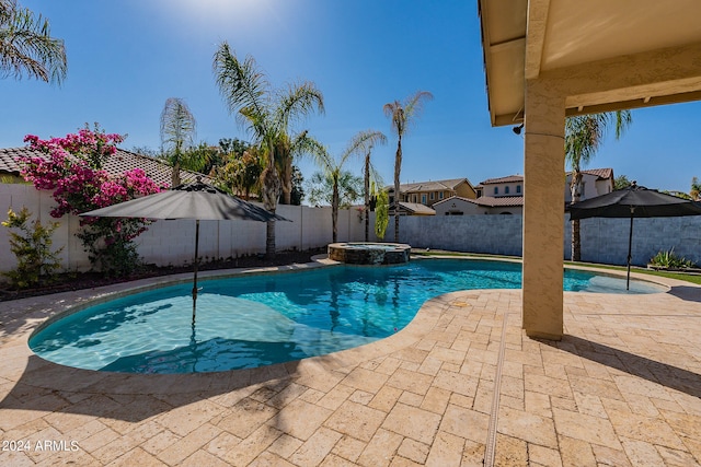 view of pool with a patio and an in ground hot tub