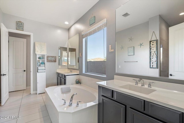 bathroom featuring tiled tub, tile patterned flooring, and vanity