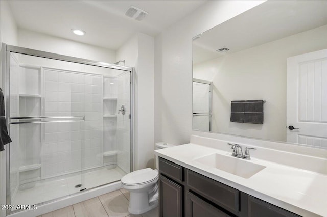 bathroom featuring tile patterned floors, vanity, toilet, and walk in shower