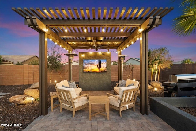 patio terrace at dusk with a pergola, grilling area, ceiling fan, and an outdoor hangout area