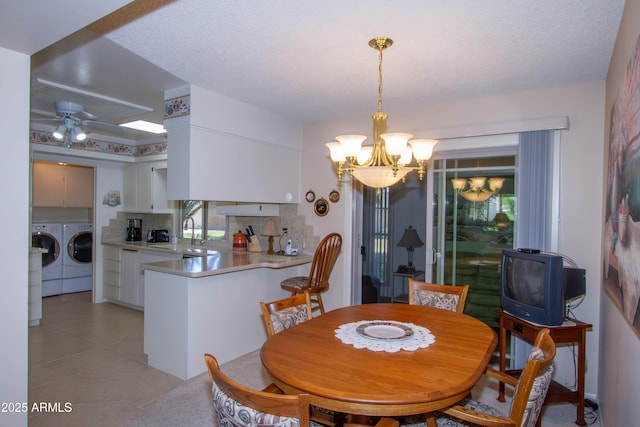 dining area featuring a textured ceiling, ceiling fan with notable chandelier, light tile patterned flooring, and independent washer and dryer