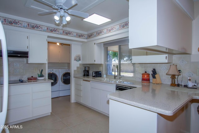 kitchen featuring sink, backsplash, independent washer and dryer, and white cabinetry