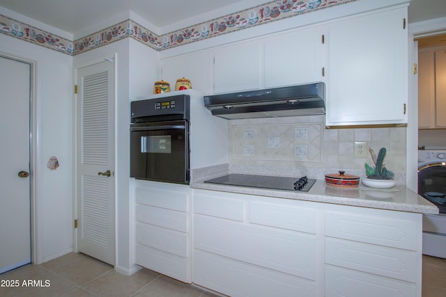 kitchen with washer / dryer, white cabinetry, tasteful backsplash, light tile patterned flooring, and black appliances