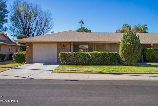 single story home with a garage, a front yard, and central air condition unit