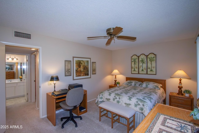 carpeted bedroom with a textured ceiling, ceiling fan, connected bathroom, and sink