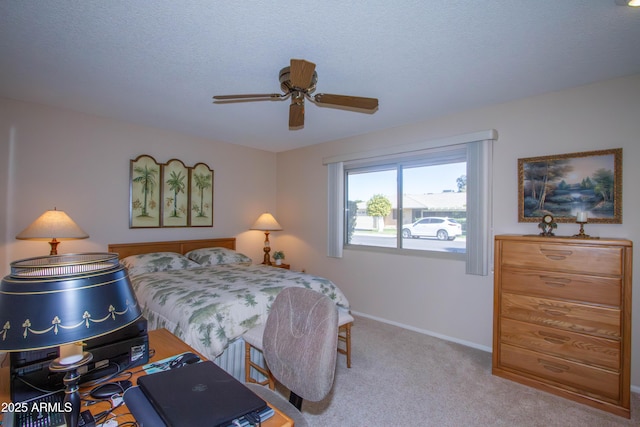 carpeted bedroom with ceiling fan and a textured ceiling