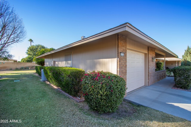 view of home's exterior with a garage and a lawn