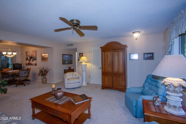 carpeted living room featuring ceiling fan with notable chandelier and a textured ceiling