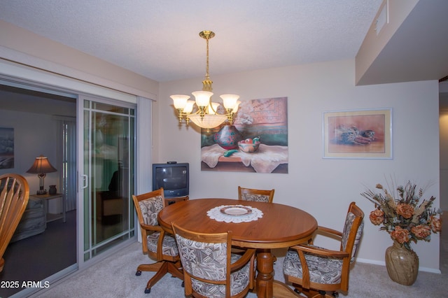 dining area with a textured ceiling, carpet floors, and a notable chandelier