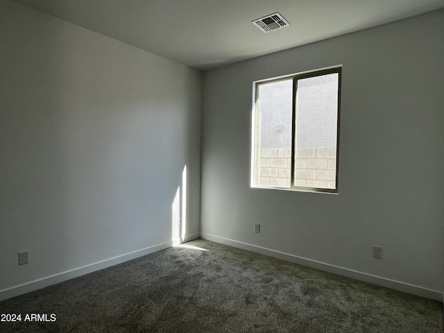 spare room featuring dark colored carpet