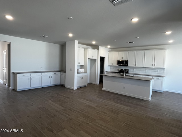 kitchen with dark hardwood / wood-style flooring, white cabinets, and stainless steel appliances