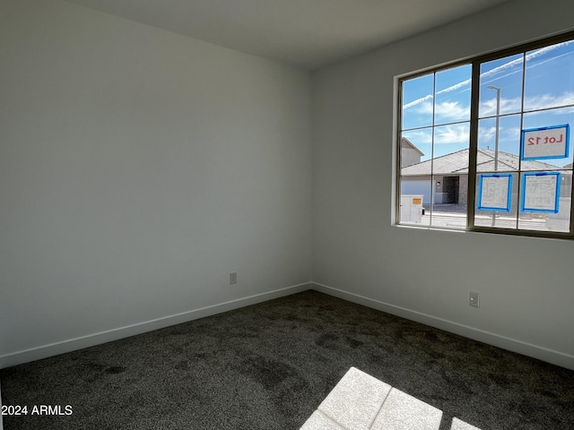 spare room with dark colored carpet