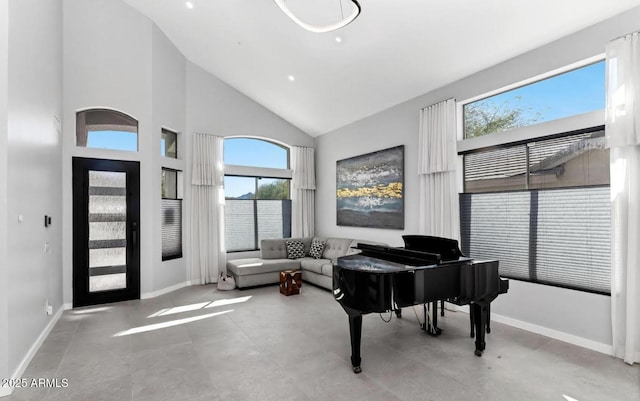 sitting room featuring baseboards, high vaulted ceiling, and a wealth of natural light
