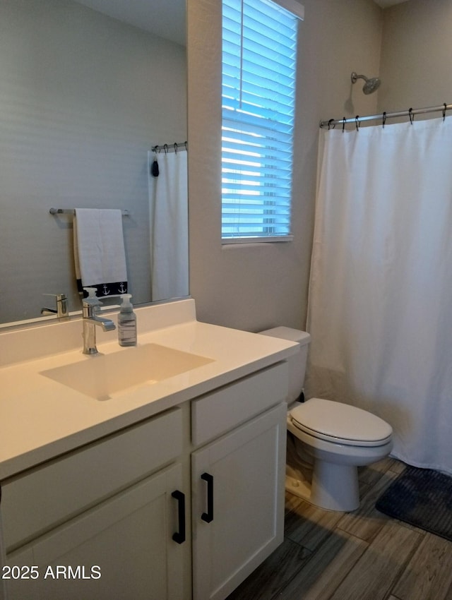 bathroom with toilet, vanity, and a shower with curtain