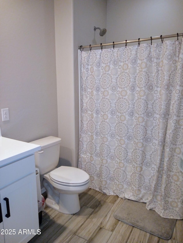 bathroom featuring toilet, vanity, and hardwood / wood-style flooring