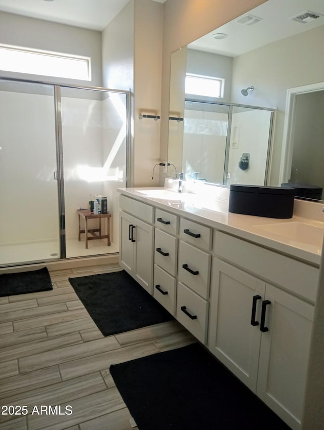 bathroom featuring walk in shower and vanity