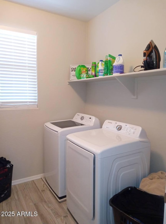 clothes washing area featuring light hardwood / wood-style flooring and washing machine and clothes dryer