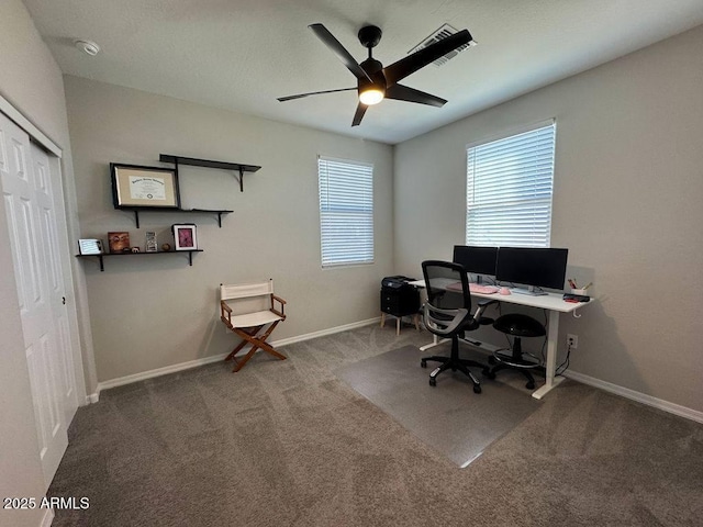 carpeted office space featuring ceiling fan