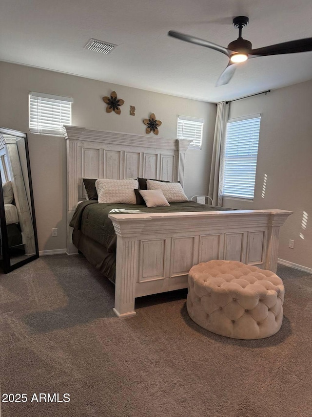 bedroom featuring multiple windows, ceiling fan, and dark colored carpet