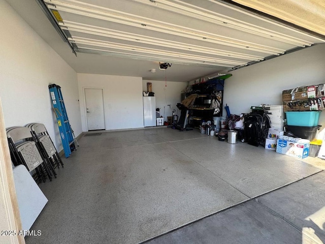 garage with a garage door opener and white fridge